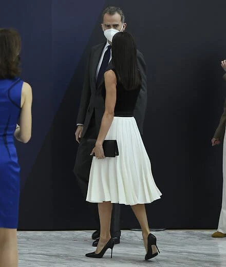 Queen Letizia wore a new white pleated skirt from Adolfo Dominguez, and black leather pumps from Manolo Blahnik, and belt from Burberry