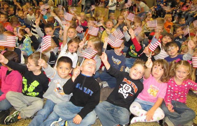 photo of: Elementary School Children Waving the American Flag for Author Visit with Debbie Clement