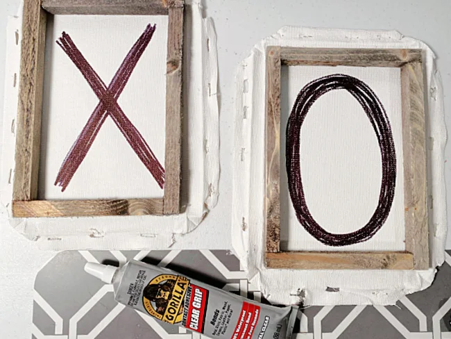 stained wooden frames on top of the x and O with glue