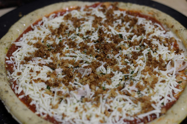 The seasoned, browned, panko bread sprinkled over the chicken parmesan pizza.