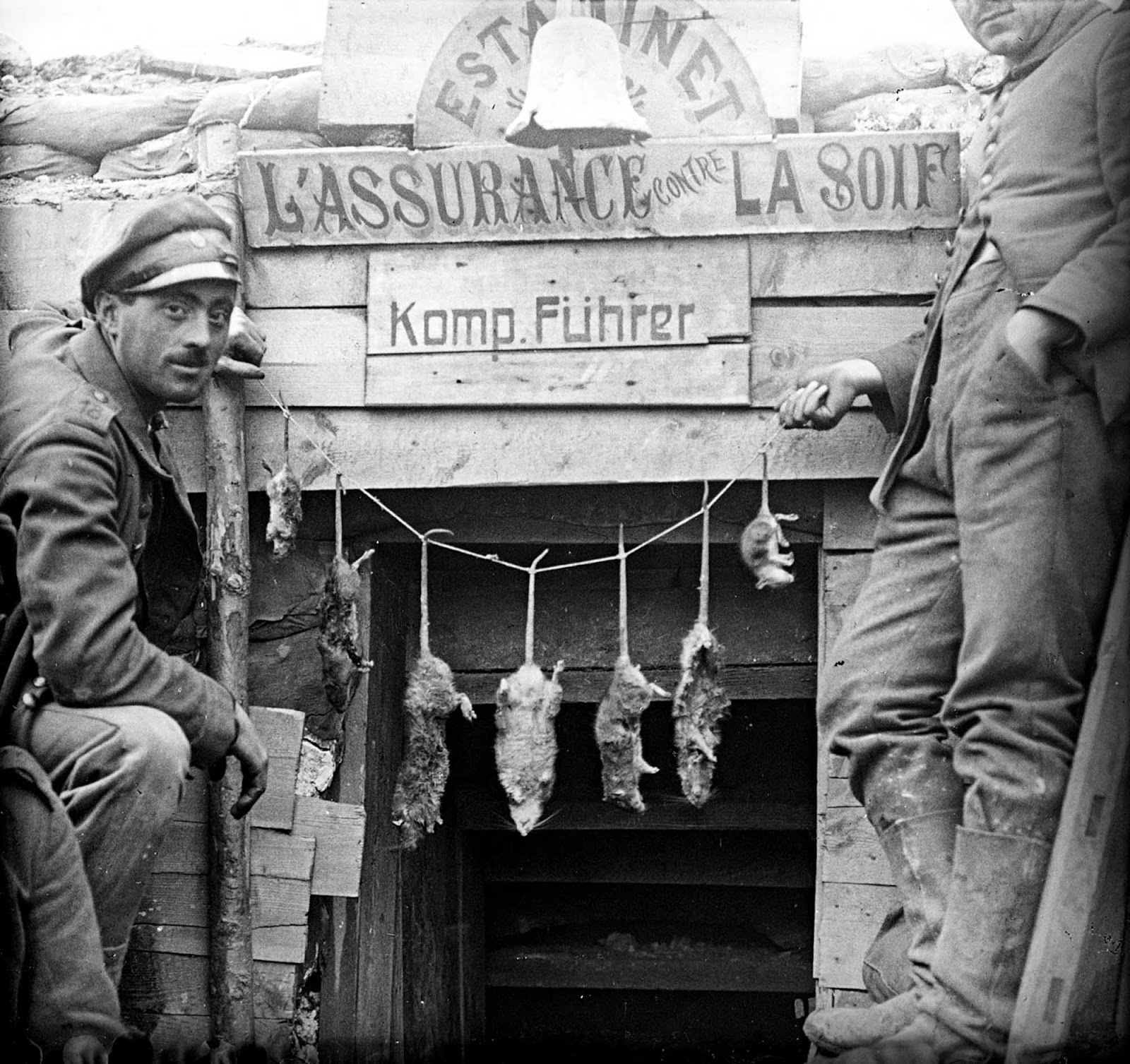 Two German soldiers posing with rats caught in their trench.