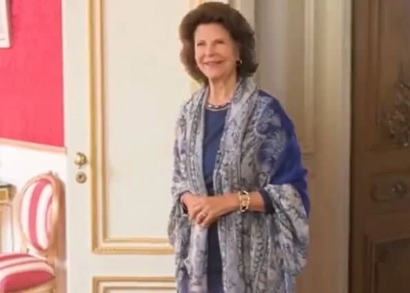 Queen Silvia wore a blue dress, and scarf, pearls necklace