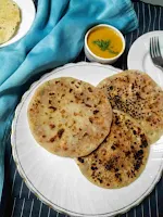 Serving onion kulcha with dal and papad