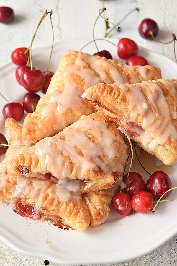 cherry turnovers with vanilla glaze served on plate