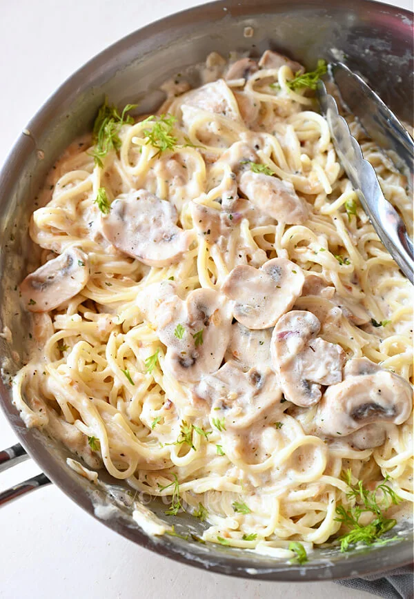 a close up of a pan with mushroom pasta with creamy sauce