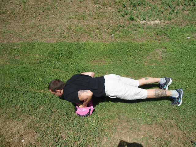 Man does pushups on The Ultimate Sandbag in a grassy field