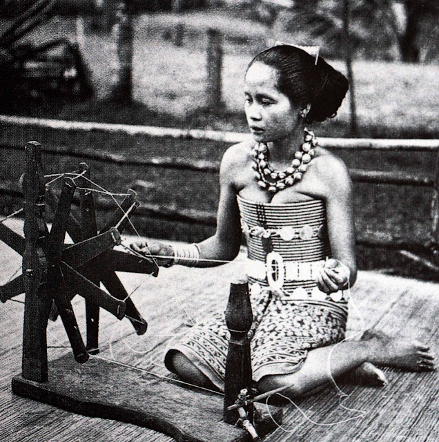A Dayak woman spinning yarn for weaving, c. 1905