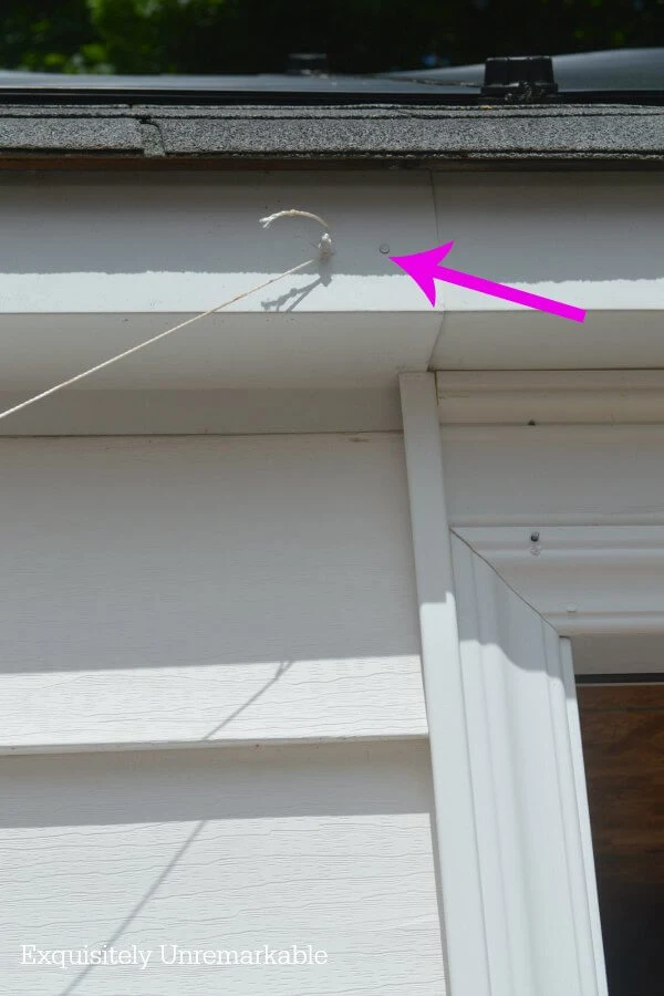 Garage door with small nails and twine attached to it