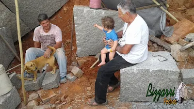 Bizzarri, com o neto, fazendo o que mais gosta, garimpando pedras. Tipos de pedras e cores diferentes. Essa da foto é um granito cinza, sendo um tipo de pedra folheta bruta e pedra paralelepípedo para fazer as construções com pedras, os muros de pedra, revestimento de pedra, calçamento de pedra, parede de pedra e pisos de pedra. Gosto de ver a pedra irregular e ela sendo colocada em vários tipos de trabalhos com pedras.