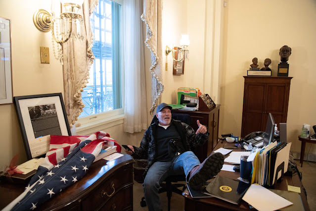 Zwolennik Trumpa siedzi na fotelu z nogami na biurku w biurze w budynku Kongresu USA