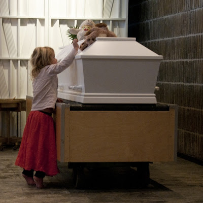 Tre-årig lille pige vil op og sidde hos sin mor, på hendes kiste - fra udstilligen Memento Mori, ved Trille Skjelborg