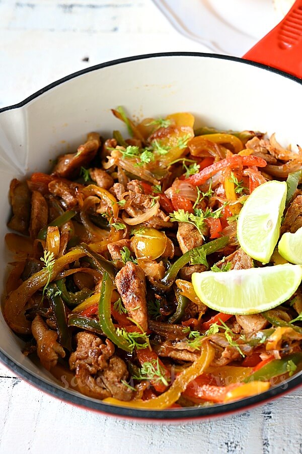 a close look of ared skillet with easy chicken fajitas