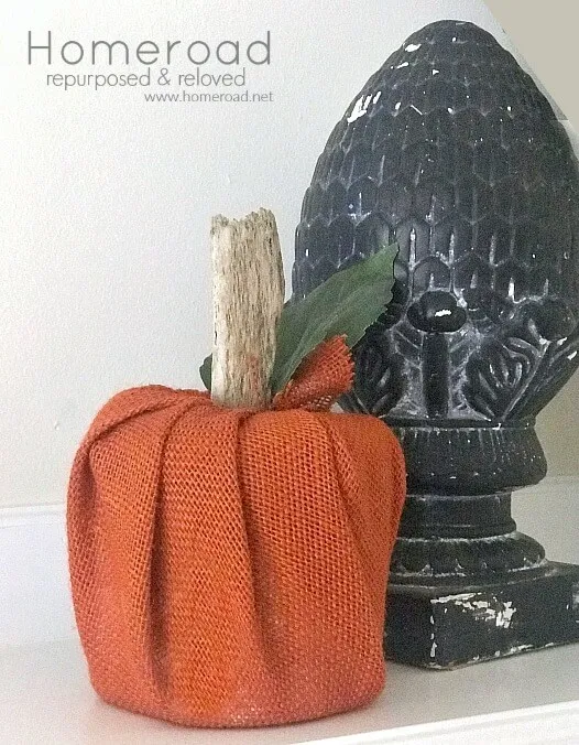 Orange burlap pumpkin next to a black artichoke sculpture.