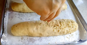 Espolvoreando queso y orégano al pan para darle mas sabor y vistosidad al pan