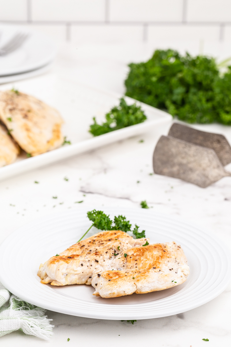 A Perfect Pan Seared Chicken Breast on a white plate.
