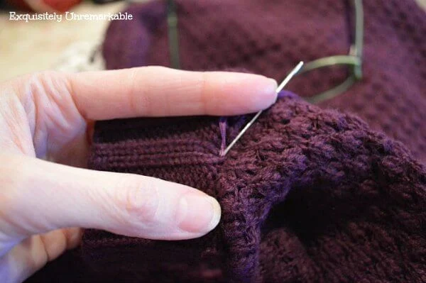 Pushing a needle and thread through the sleeve knit