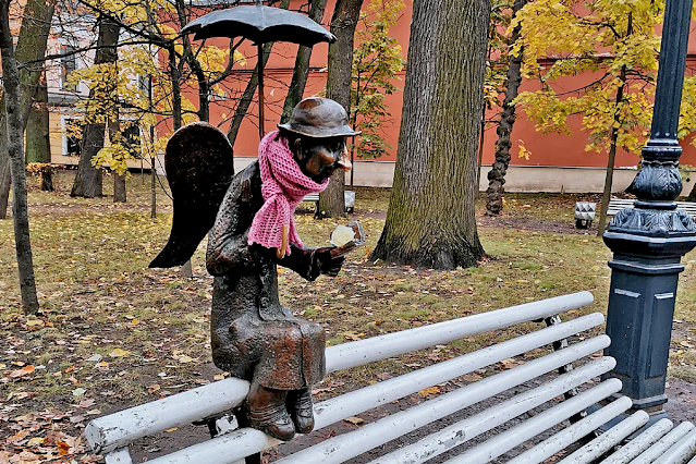 Погода стояла ненастная, как обычно бывает осенью в Санкт-Петербурге, и кто-то из прохожих заботливо укутал маленького ангела шарфом.