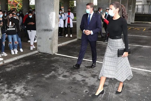 Queen Letizia wore a check wool skirt from Massimo Dutti, and black cashmere sweater from Hugo Boss. Carolina Herrera pumps and clutch