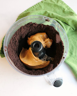 food processor filled with oreo crumbs and peanut butter ready to make oreo balls