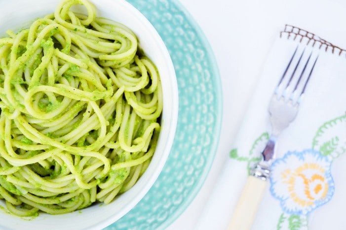 A bowl of spaghetti coated in  creamy green sauce