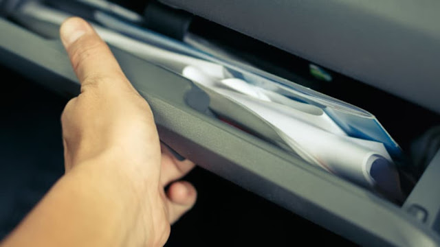 Seguros para furgonetas camper Persona cogiendo papeles del coche