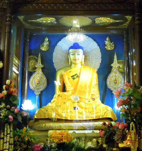 A gilded stone statue of the Buddha inside the shrine room (garbagriha) of the Mahabodhi Temple, Bodhgaya. It was probably made during the Pala period (c. 1100 CE).