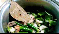 Fresh cilantro leaves, green chili, bay leaf and other spices in a mixing jar to make chicken cafreal recipe masala