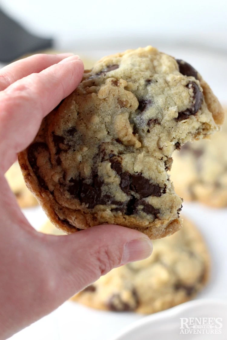 Close up of DoubleTree Chocolate Chip Cookie with a bite taken out being held by a hand