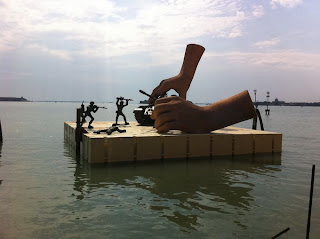 Escultura gigante de manos y soldaditos de plomo