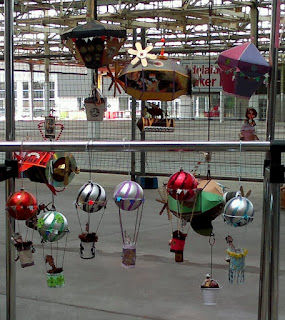 'Hot air balloons' crafted from Christmas baubles and paper and string, and dirigibles made of folded paper and other craft embellishments.