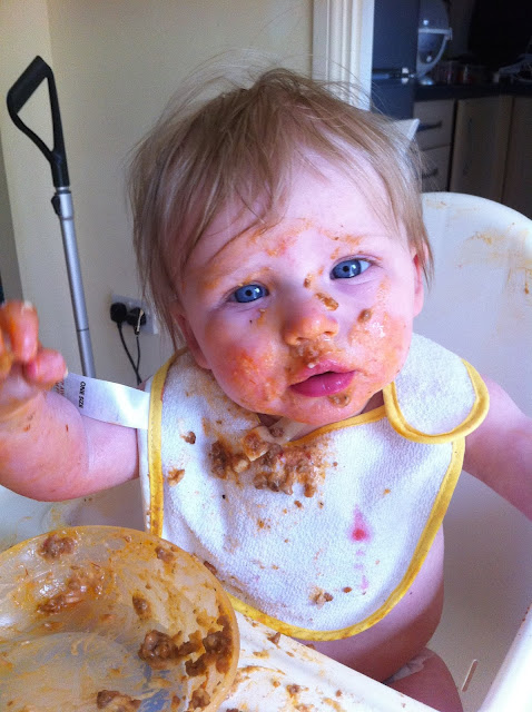 Lasagne face a baby covered in lasagne, sitting in an IKEA highchair in just a nappy and small bib