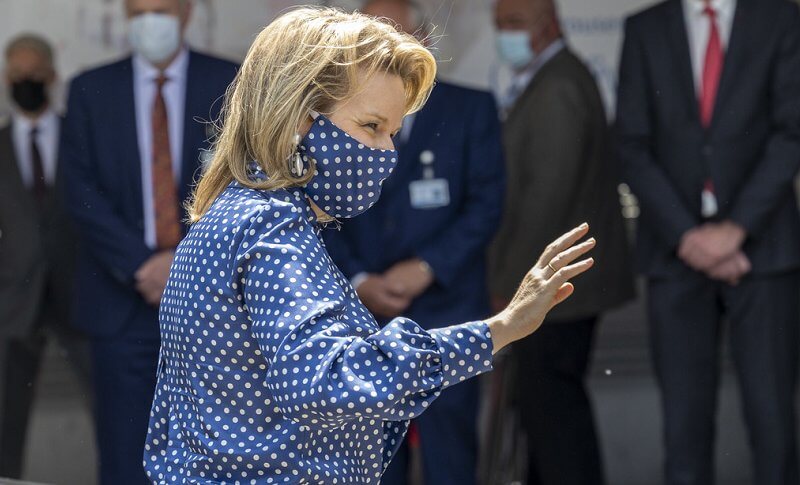 Queen Mathilde wore a navy polka-dot print tie neck blouse from Natan, and polka dot mask, white trousers
