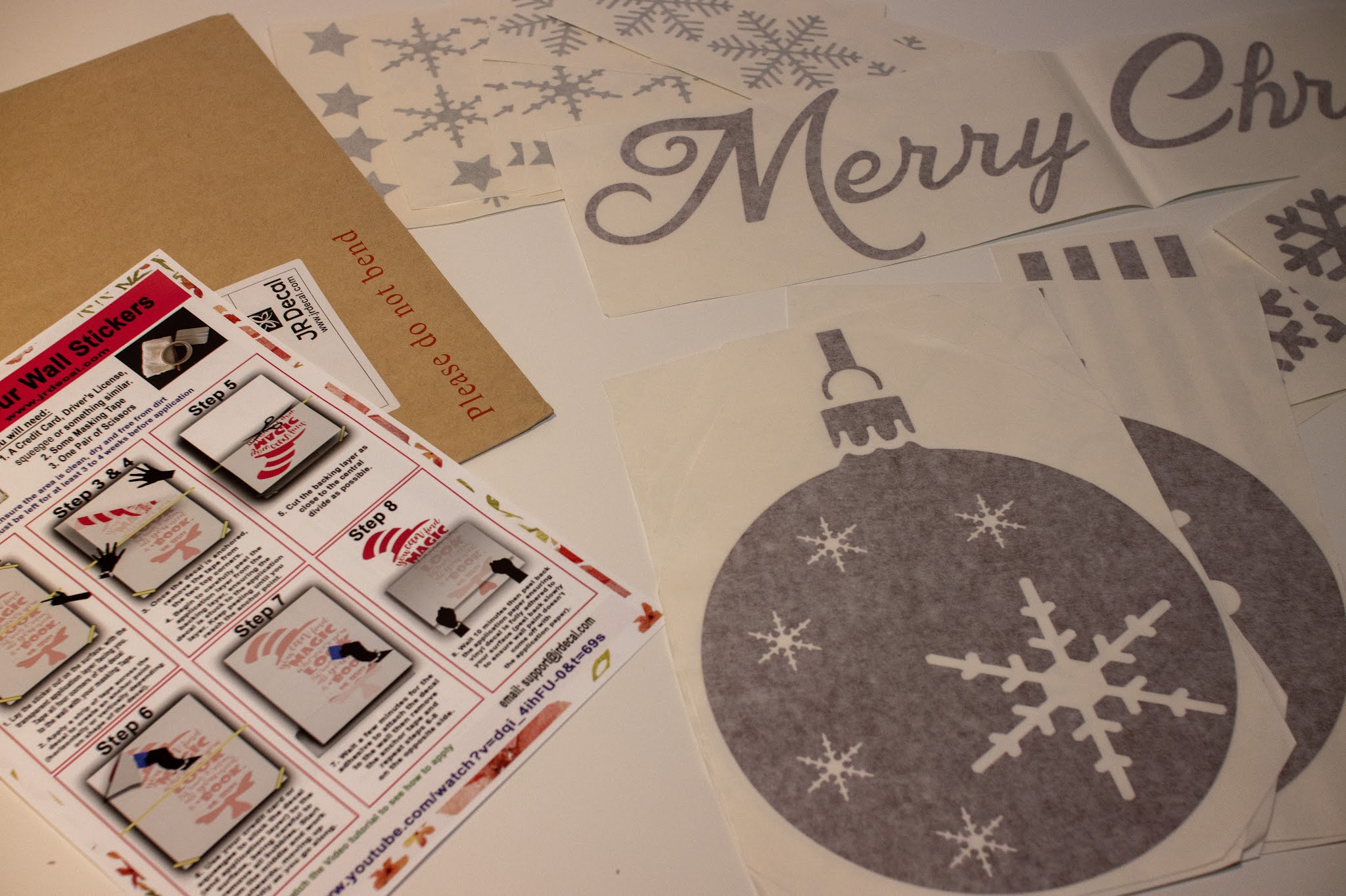 An envelope with review Christmas Wall stickers from JR Decal showing the instructions and the wall stickers in separate pieces