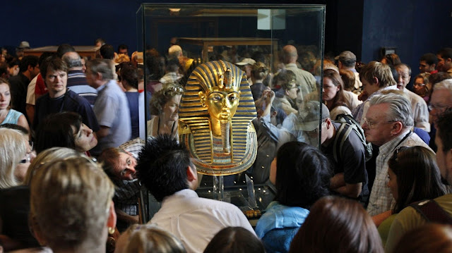 Люди толпятся вокруг золотой маски короля Тутанхамона в Египетском музее в Каире