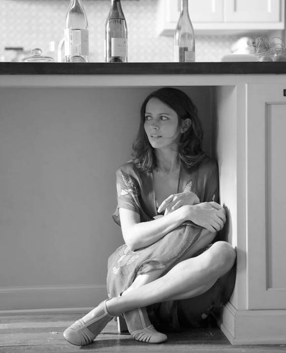 Amy Acker hiding under the counter in a kitchen nook
