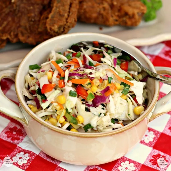 Firecracker Coleslaw by Renee's Kitchen Adventures in a bowl on a white and red checkered table cloth