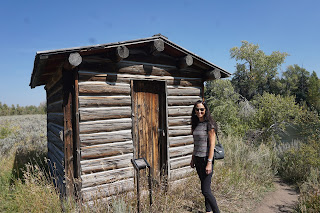 woman standing in front of historic cabin