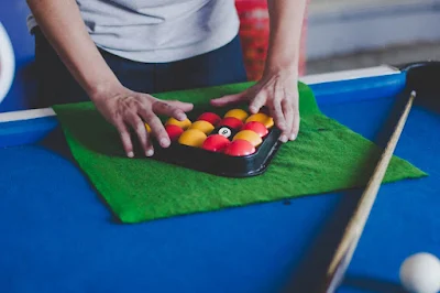 A referee racking red and yellow UK 8ball pool snooker balls