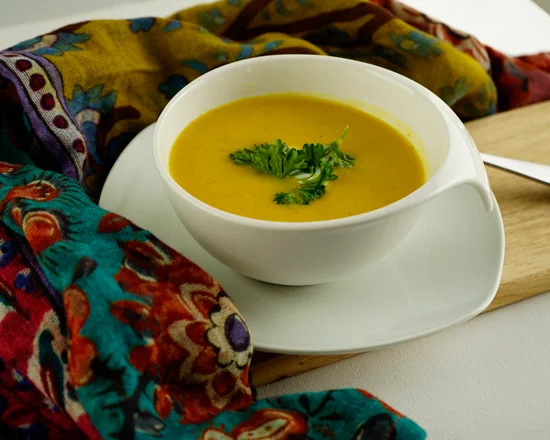 A bowl of squash soup on a table.