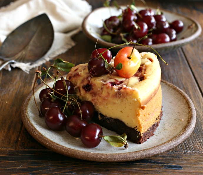 Recipe for cheesecake with a brownie base and cherry preserves swirl.
