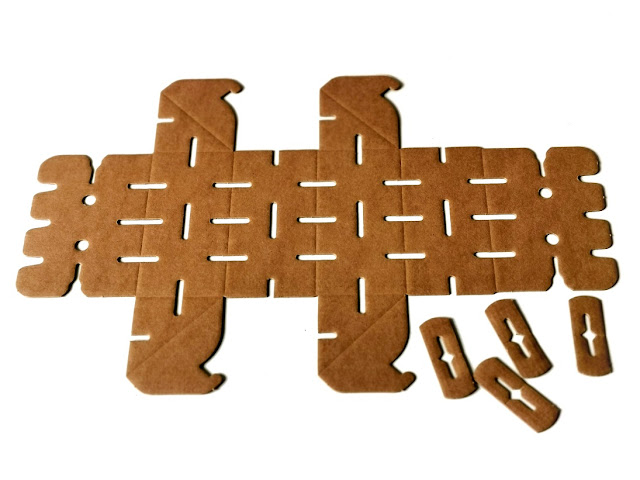 na zdjeciu pojedynczy jeszcze nie złożony klocek, płaski fragment kartonu ponacinany w wielu miejscach z zaznaczonymi liniami zgiecia