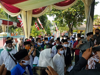 Yoni & Ikbar Daftar ke KPU, Sayang Setidaknya Ada 3 Kekisruhan Mojokerto - majalahdetektif.com : Dua Calon pasangan Bupati Mojokerto pada Jumat (4/09/2020) sejak pukul 07.30 WIB hingga jelas Mahrib KPU Kabupaten Mojokerto telah menerima dan meneliti pendaftar Bakal Calon Bupati dan Wakil Bupati secara Administrasi. Sejak saat itu mulai ada kekisruhan terkait Pelayanan pendaftaran, antrian Cabup Yoni lebih didahuluan dari pada Cabup Ikbar yang mengklaim antri lebih dulu, hingga Tim Ikbar melalui sesepuhnya Ikbar Kyai Asep sempat turun gelanggang bertanya dan protes pada KPU, namun sesuai penelusuran media ini Kyai kharismatik ini mengalah alasanya Jumat itu hari Mubarok Cabup Ikbar lebih suka dapat mubarok mulai pagi hingga jelang malam meski Timnya terlihat kecapekan berada di KPU mulai Jam 07.00 hingga usai hampir pukul 16.00 WIB. Saat ditemui media ini jelang sholat Jamaah Magrib di Ponpes Kembangbelor, Kyai Asep sempat memberikan petuah dan harapan. Hari Jumat itu memang hari Mubarok memang lebih pagi bekerja lebih baik namun yang lebih lama dan lebih sabar akan mendapat barokah dari Allah. "Kita tahu Cabup Ikbar ibarat antri beli tiket di KPU sebenarnya paling pertama antri namun dijadikan nomor dua ya kita sabar dan pihak sebelah memang mengejar Jumat paginya, namun yang tahu ilmunya di hari Jumat jika kita bekerja keras dan bersabar mulai pagi hingga jelang malam seperti apa yang dilakukan Tim Ikbar termasuk teman wartawan pasti dapat barokah, harapan kami untuk KPU dan Bawaslu kami harap kedepannya lebih adil dan melayani dengan sebaik-baiknya agar kerja kerasnya mendapat barokah," ujar Tokoh yang dekat dengan Gubernur Jatim ini. Menanggapi kekisruhan pertama dalam Jumpa Pers yang digelar yang diikuti hampir 40 media, KPU menjelaskan Cabup Yoni lebih didulukan antriannya sebab di hari sebelumnya sudah melayangkan surat pemberitahuan hendak mendaftar pukul 08.00 WIB dan Cabup Ikbar tanpa pemberitahuan dan antri lebih pagi daripada Cabup Yoni. "Memang betul Cabup Ikbar sejak dibuka pendaftaran Antri lebih dahulu namun jika kita terima bersama juga tidak memungkinkan maka kita menerima Cabup Yoni lebih dahulu yang secara administrasi memberi tahu jam 8 hendak mendaftarkan diri , maka kita mendahulukan Cabup Yoni jam 8, pendaftar lainnya ikuti antrian," jelas Ketua KPU Muslim Buchori. Sementara itu, Jainul Arifin selaku Divisi sosialisasi pendidikan pemilih, SDM dan Partisipasi Masyarakat KPU Kabupaten Mojokerto saat dikonfirmasi media ini disela-sela Jumpa Pers juga tidak bisa menunjukkan kapan pastinya Cabup Yoni memberikan surat pemberitahuan termasuk kisruh antrian dan pelayanan Cabup Yoni dan Cabup Ikbar. "Seingat saya dua atau tiga hari sebelum pendaftaran Cabup Yoni memang kasih surat pemberitahuan pada KPU mau mendaftar hari pertama pendaftaran 4 September jam 8 pagi, namun Cabup Ikbar saya tidak tahu persis termasuk keputusan KPU mendahulukan Cabup Yoni dalam pelayanan, coba tanyakan Pak Arif yang tahu persis dan sebagai Ketua pelaksana panitia Pendaftaran," jelas Bang Jay panggilan akrabnya. Kekisruhan kedua, saat Cawabup Ikbar Gus Barra yang sempat dipermasalahkan KPU dan menunggu rekomendasi Bawaslu. "Sesuai penelitian kami, Cabup Yoni sudah memenuhi semua syarat dan sudah kami buatkan berita acara penerimaan pendaftaran, namun maaf Cabup Ikbar masih belum lengkap terpaksa belum kita buatkan berita acaranya, akibat Cawabup Ikbar Gus Bara belum menyerahkan Hasil Swab covid 19, ini secara administrasi, Cabup Ikbar kami terima dengan catatan, tentang keputusan dan rekomnya kami serahkan pada Bawaslu kemudian bakal kita tindaklanjuti," ujarnya. Sesuai pantauan media ini, kekisruhan ketiga terjadi saat pendaftaran, ada kampanye lintas udara mengkampanyekan Cabup Yoko-Nisa melalui seorang atlit nasional paralayang asal Mojokerto yang terus menerus melintas diatas kantor KPU, Atlet tersebut mulai take off di lapangan Surodinawan dan terus menerus melintas diatas kantor KPU dan sekitarnya, Kampanye yang belum waktunya itu sempat diprotes Tim Cabup Ikbar, alasannya Kampanye baru dimulai 26 September mendatang hingga 7 Desember namun Cabup Yoni sudah mulai kampanye dan pihak Bawaslu sebagai Juri juga membiarkannya hingga kampanye tersebut selesai. Media ini juga memonitor ada kekisruhan pelayanan dan kerjasama wartawan yang meliput acara penting tersebut, akibat wartawan dihalang-halangi untuk Liputan didalam Gedung KPU Kabupaten Mojokerto, menurut Pantauan media ini, dari Mitra Wartawan Pemerintah Kabupaten Mojokerto, ada 60 media dan yang resmi kerjasama dengan KPU sebanyak 40 media, sayangnya hanya 10 media yang diperkenankan masuk arena peliputan, padahal space masih ada, sehingga sepanjang pagi hingga sore para wartawan dari puluhan media massa banyak yang 'kleleran' dan 'klesetan' diluar gedung KPU tanpa punya tempat duduk dan istirahat yang pasti, fasilitas dan konsumsipun tak tersedia kecuali 1000 nasi bungkus dari Cabup Ikbar, padahal mereka semua liputan mulai jam 07.00 hingga jelang Magrib. "Jumlah wartawan yang resmi ngepos dan bekerjasama dengan Pemerintah Kabupaten Mojokerto itu hampir 60 media itu sudah diteliti dan disaring oleh Humas Pemkab, yang kerjasama dengan KPU ada 40 media, jika KPU atau Polisi mengharuskan tidak semuanya boleh melakukan peliputan apa itu tidak melanggar dan menginjak-injak UU Pokok Pers, jelas ada pasal menghalang-halangi peliputan itu ada perkara pasal dan ancamanpun hukumannya jelas ada, Hari ini KPU Kabupaten Mojokerto dan Bawaslu jelas ngak adil ayo terus kita kritisi dan kontrol tanpa takut, Terus teman juga banyak yang menanyakan dana untuk media yang diajukan KPU 3 Milyar untuk media dananya untuk apa, dikemanakan, jangan ada lagi dikriminasi, 'Mban cinde mban ciladan, sopo siro sopo ingsun'. KPU harus yang adillah dan transparan, ingat sejak pagi hingga jelang Magrib standby di KPU tidak dapat berita situasi yang di dalam KPU dan foto yang bagus karena hanya dikirimi Foto situasi gedung bukan hasil karya original kami. Harusnya bergantian masuknya. Ini pekerjaan berat, kleleran lagi," keluh mayoritas wartawan yang hadir dan liputan saat itu. (Achmad Mardianto)