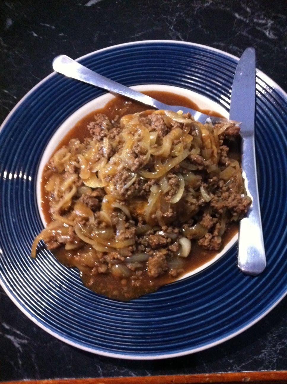 What I Eat Mince and onion in gravy over baked potato and grated cheese.