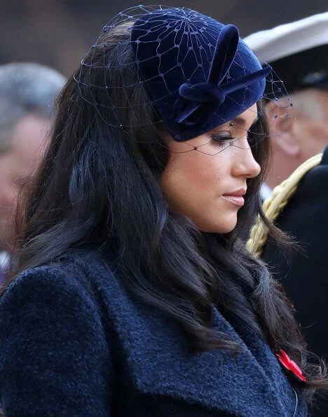 Meghan Markle wore Sentaler long wide collar wrap coat, Philip Treacy hat, Tamara Mellon boots. Royal British Legion traditional paper poppy