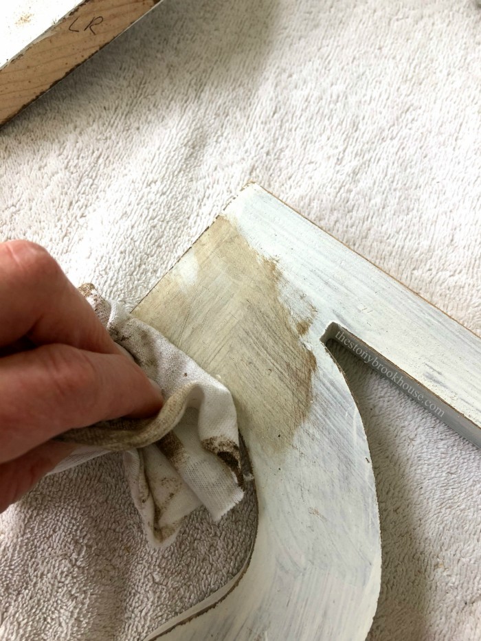 wiping off antiquing wax on corbels