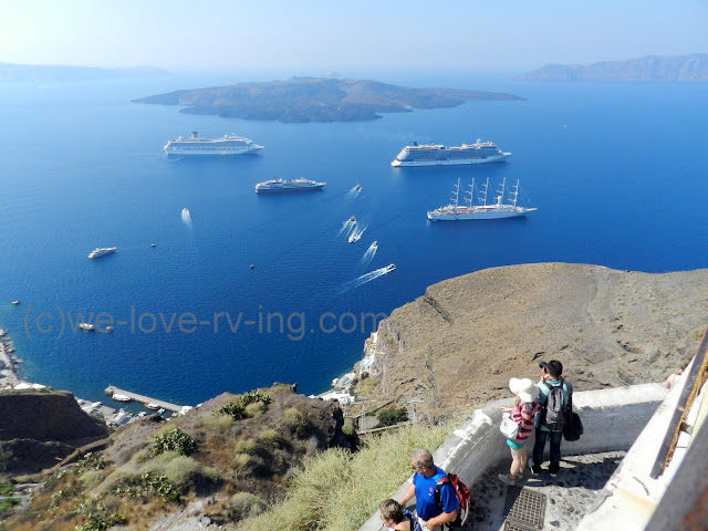 All sizes of ship sit in the harbour below Fira in Santorini