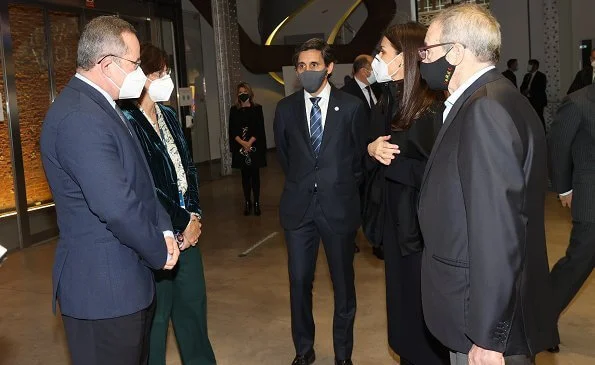 Queen Letizia wore a black capina poncho cape from Hugo Boss, and draped-neck ribbed wool dress from Cos. Steve Madden boots and Burberry belt