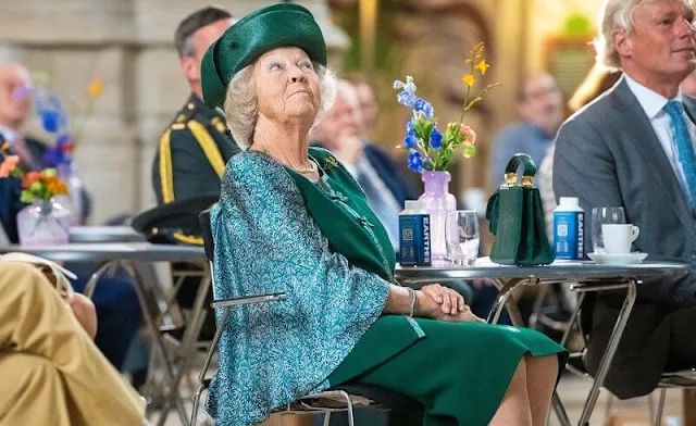 The Princess wore a green embroidered skirt suit, embroidered cape and green hat, gold brooch