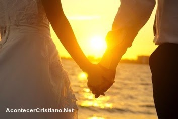 Enamoramiento cristiano - Pareja tomados de la mano frente al mar
