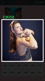 женщина силой мускулов хочет раздавить яблоко в руке